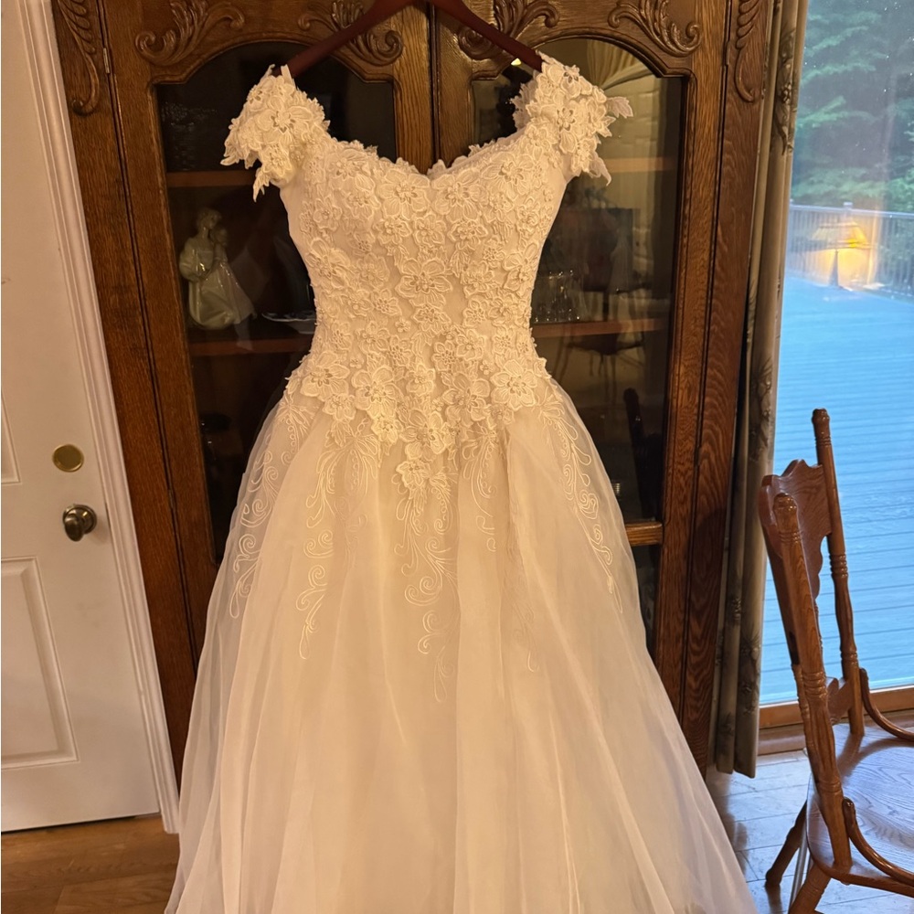 A beautiful EVE of Milady Size 4 Wedding Gown, an 8 ft train along with the veil